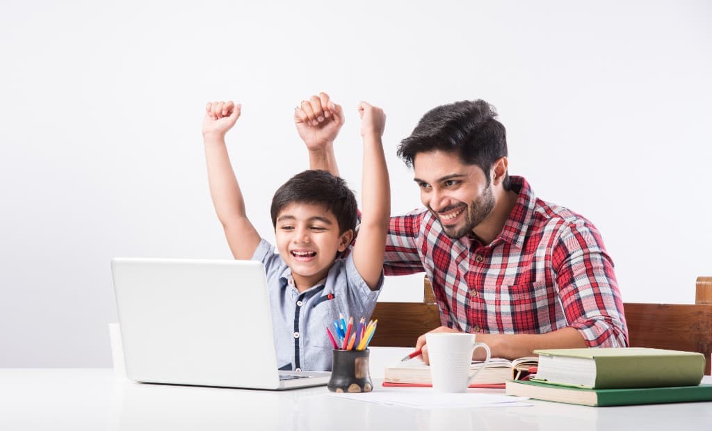Student and mentor celebrating success with laptop